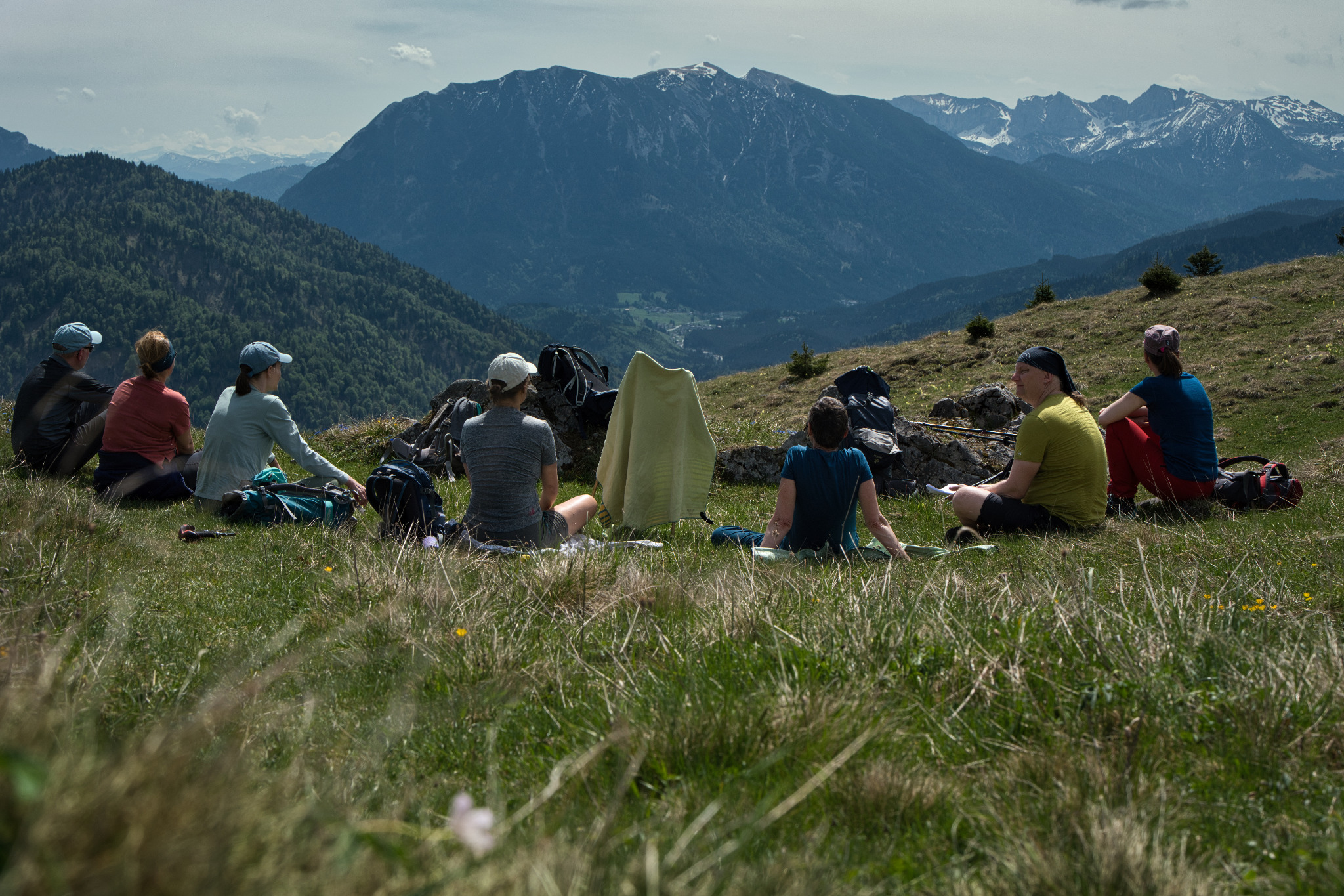 Wandergruppe bei einer gemeinsamen Pause mit Blick auf die Berge